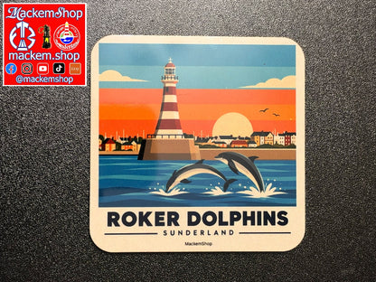 A Roker coaster featuring a retro-style illustration of the Roker Dolphins in Sunderland, with two dolphins jumping in front of a lighthouse at sunset. The coaster is placed on a dark textured surface, with a red MackemShop logo overlay in the top-left corner.
