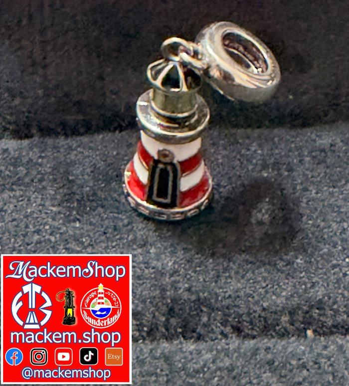 A silver charm Roker lighthouse with red and white stripes, displayed on a dark textured surface. A red promotional graphic for 'MackemShop' is overlaid in the bottom-left corner.