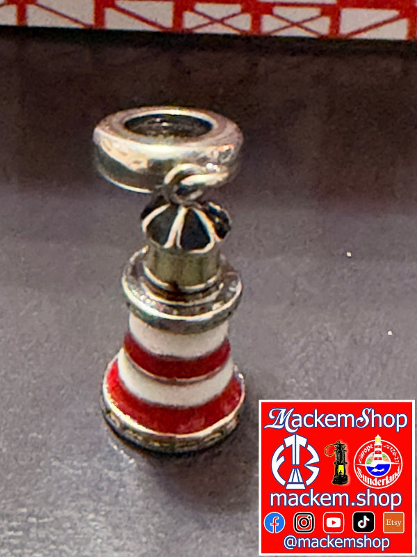 A silver-toned Roker lighthouse-shaped charm with red and white enamel stripes, shown on a dark surface with a MackemShop watermark in the bottom right corner.
