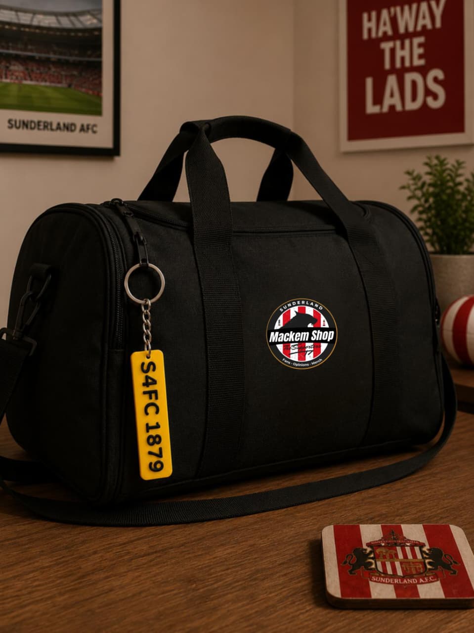 Black duffel bag with a badge and keychain on a wooden surface, with a sports-themed background.