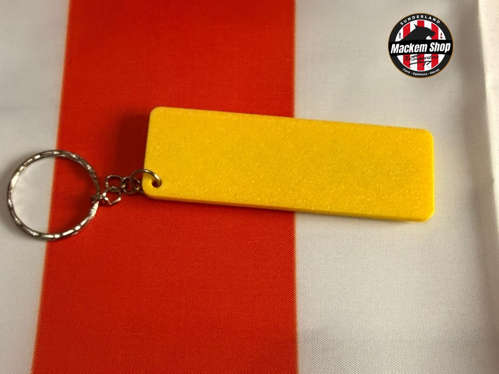 Yellow keychain on a red and white striped background with 'Mackem Shop' logo.