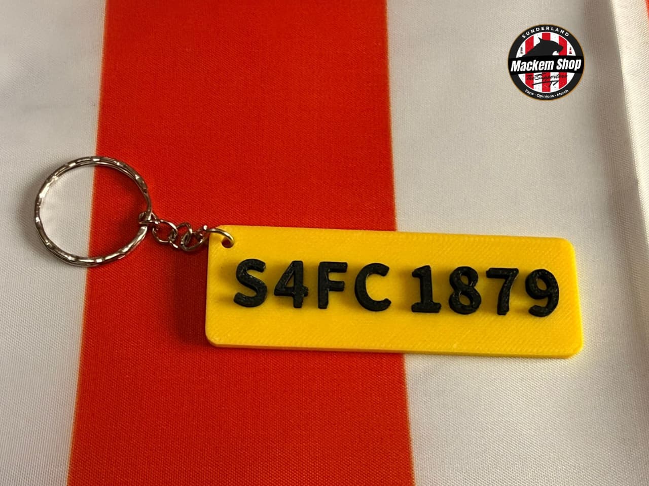 Yellow keychain with 'S4FC 1879' on a red and white striped background