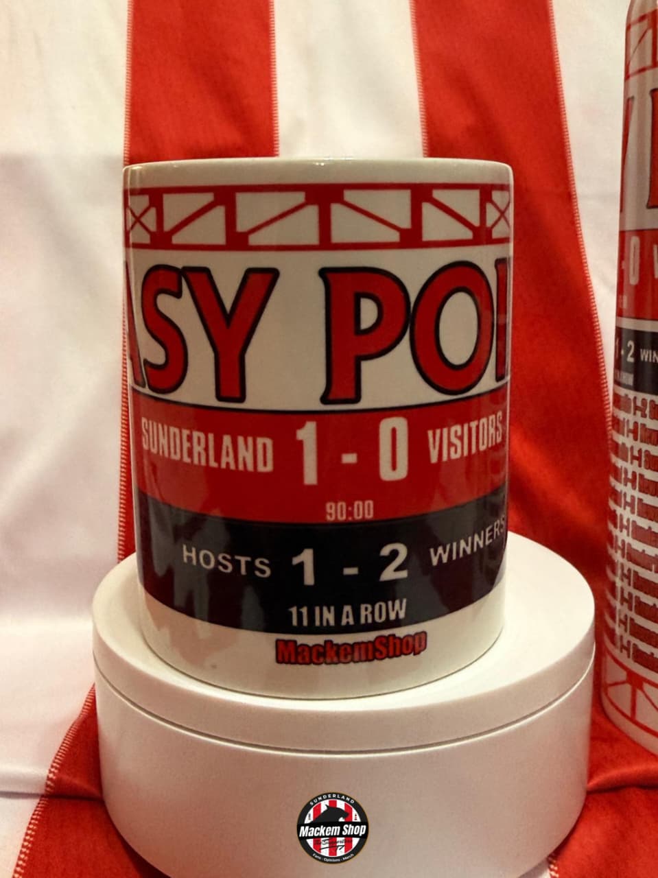 Mug with sports-themed design on a red and white striped background