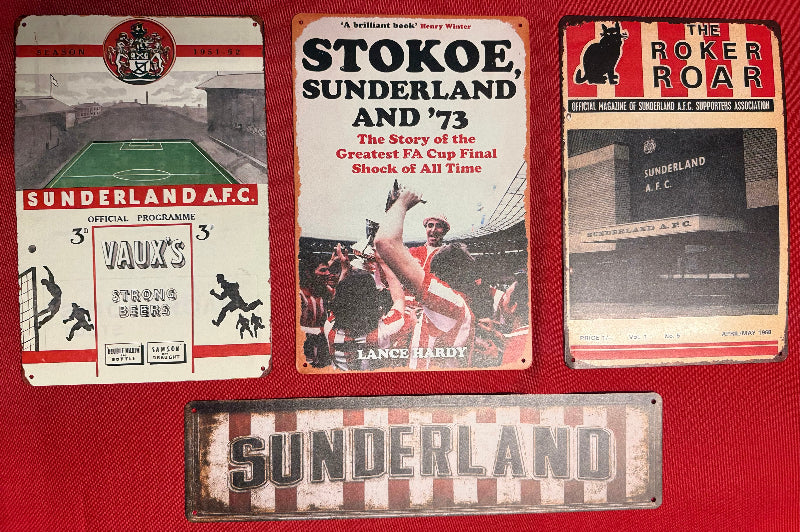 Collection of Sunderland AFC memorabilia including a program, book, and sign on a red background.