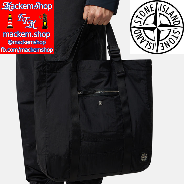 Black tote bag held by a person with Stone Island logo in the corner