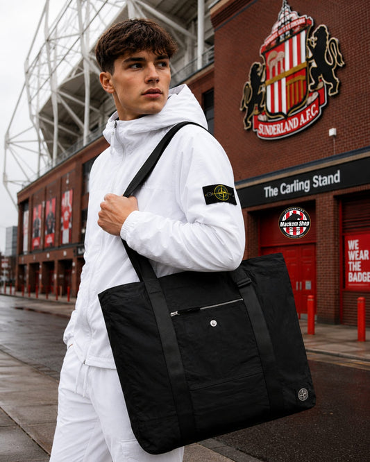 Person holding a black tote bag in front of Sunderland AFC stadium