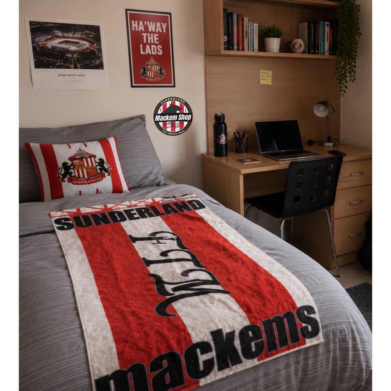 Room with bed featuring a Sunderland beach towel, desk with laptop, and decor items.