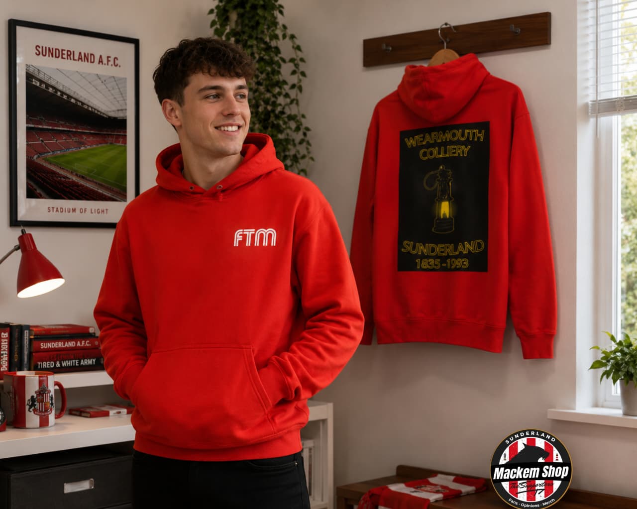 Person wearing a red hoodie with 'FTM' logo, standing next to a similar hoodie on a hanger.