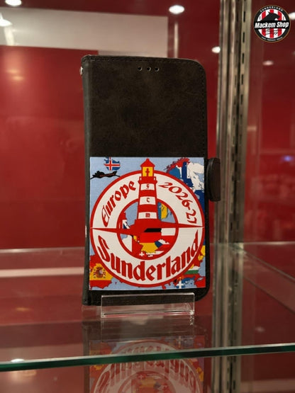 A black folio-style phone case with a colorful printed graphic on the Front, displayed on a glass stand inside a glass case. The graphic features a red and white lighthouse design with the text 'Europe 2026' and 'Sunderland'.