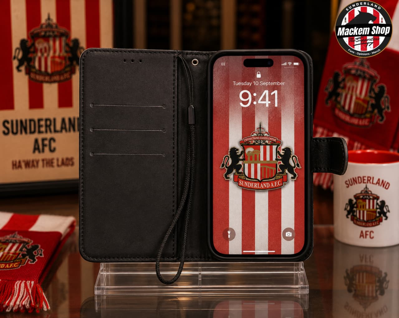 A black folio-style iphone case with a wrist strap, shown open and holding a smartphone. The phone screen displays a red-and-white striped Sunderland AFC design.