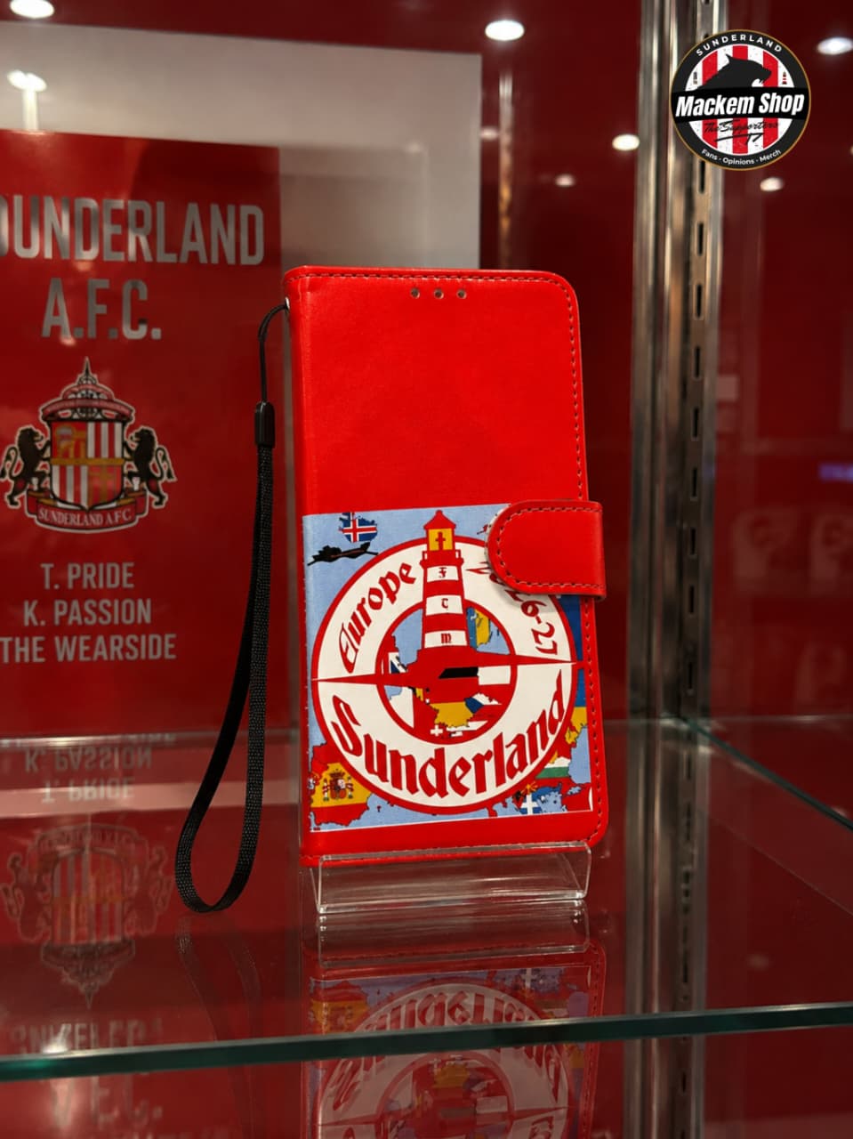 A red Flip iPhone case with a Sunderland A.F.C. crest graphic, displayed on a glass stand inside a red shop display case.