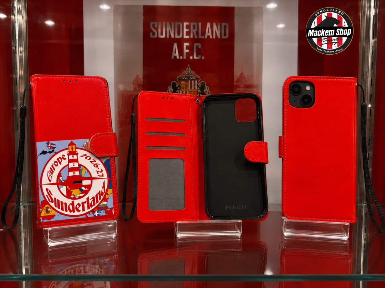 Three red iPhone wallet cases displayed on clear stands inside a glass case, featuring Sunderland A.F.C Europe League tour 26-27.