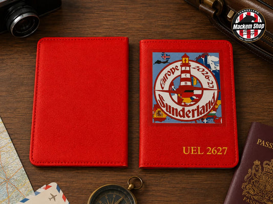A red passport cover shown closed and open on a wooden desk, with a colorful Europe 2026 Sunderland lighthouse graphic and the text 'UEL 2627' printed on the inside cover. Surrounding props include a camera, a compass, a passport, and a Mackem Shop logo badge.