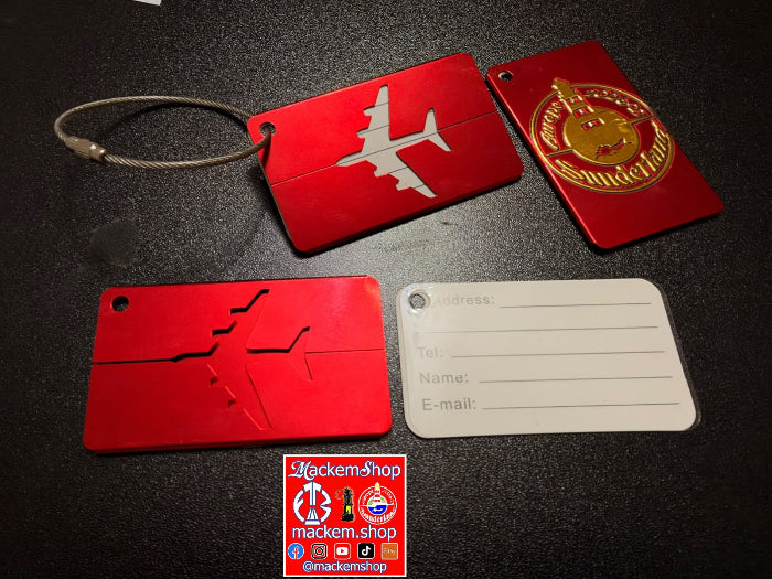 A set of red luggage tags and a white name tag displayed on a dark textured surface. The set includes a zippered luggage tag with an airplane silhouette, a round luggage tag with a gold emblem, a flat luggage tag with an embossed crack design, and a blank white name tag with fields for address, tel, name, and email.
A MackemShop Logo is in the middle downside.