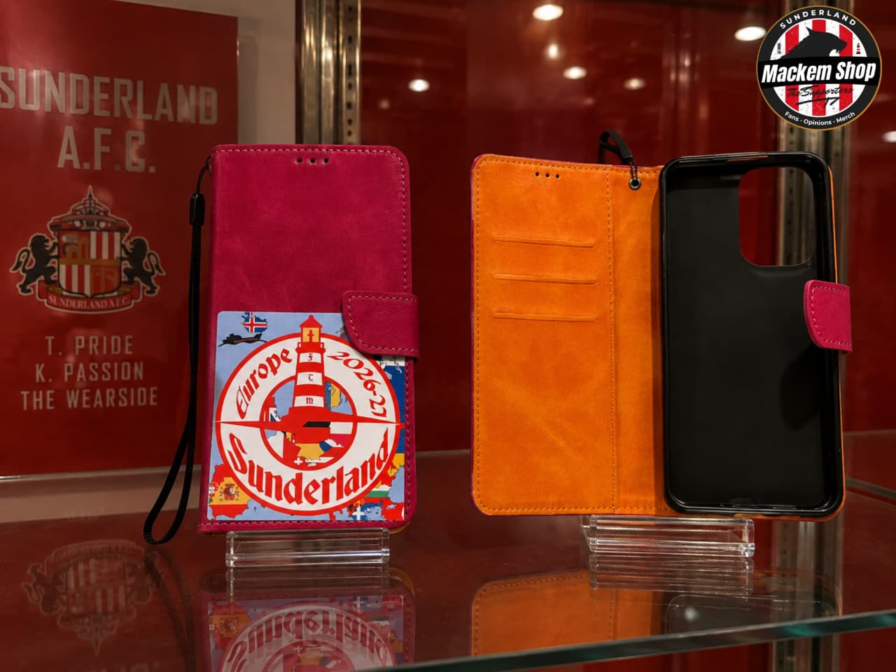 Two mobile wallet phone cases displayed on clear stands in a retail setting. The left case is closed, showing a magenta-pink exterior.