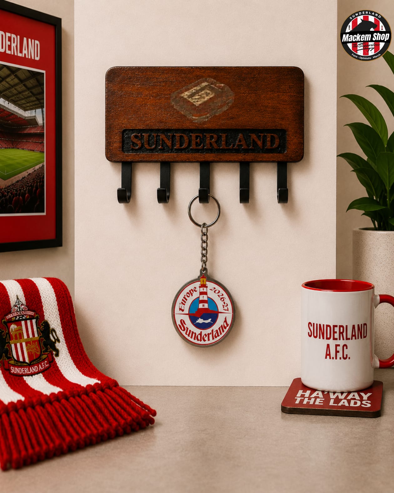 A wooden Sunderland AFC wall-mounted key holder with five hooks, shown in a styled room setting with a red and white striped scarf, a framed match poster, a plant, and a Sunderland A.F.C Keychain.