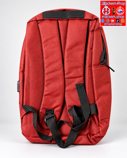 A red backpack shown from the back, featuring padded shoulder straps, a top handle, a side zippered pocket, and a visible USB-C charging port on the side. A 'mackemShop' logo is visible on top right corner.
