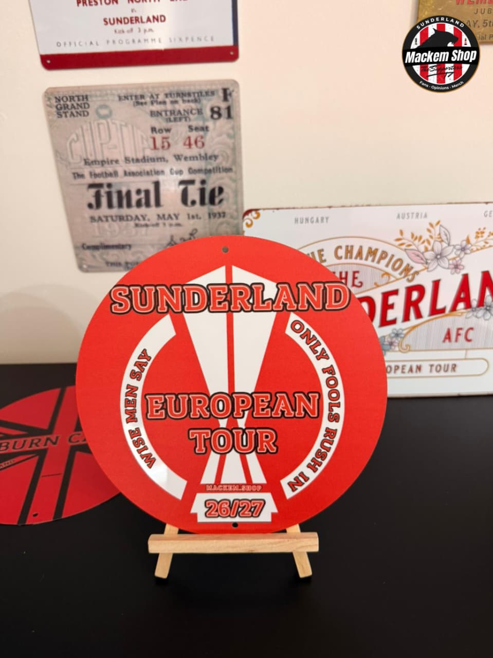 Red and white metal sign with 'Sunderland European Tour' text on a stand, with vintage Sunderland AFC memorabilia in the background.