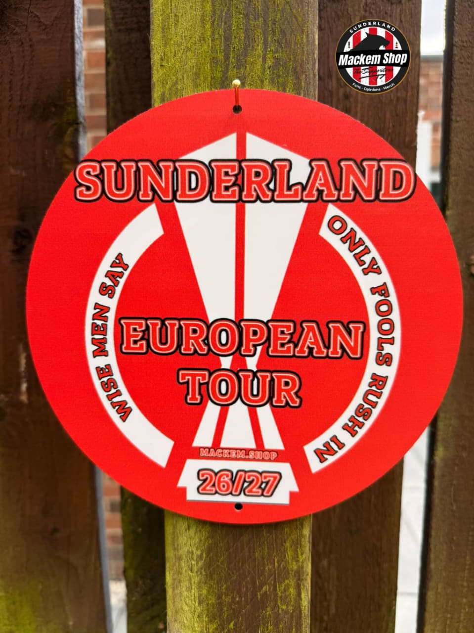 Circular red sign with 'Sunderland European Tour' text on a wooden post.