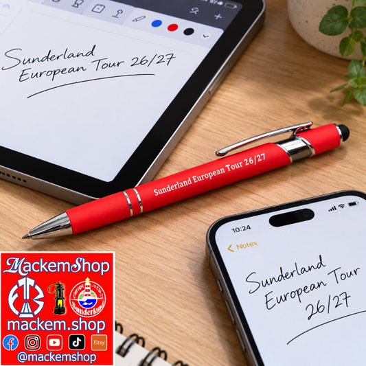 A red retractable ballpoint pen with silver accents and 'Sunderland European Tour 26/27' printed on the barrel, displayed on a wooden desk alongside a tablet and a smartphone. A 'MackemShop' logo overlay is in the bottom-left corner.