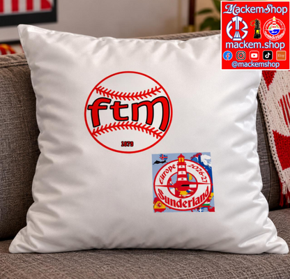A pillow displayed on a gray couch. The pillow features a red baseball graphic with FTM written on it, with Sunderland Europe 2026-27 patch, alongside MackemShop logo visible on top right corner.