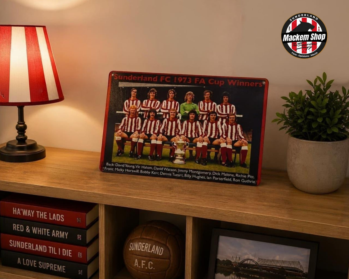 A rectangular Metal sign of the Sunderland FC 1973 FA Cup Winners team, displayed on a wooden shelf in a styled room setting with a lamp, potted plant, and books.