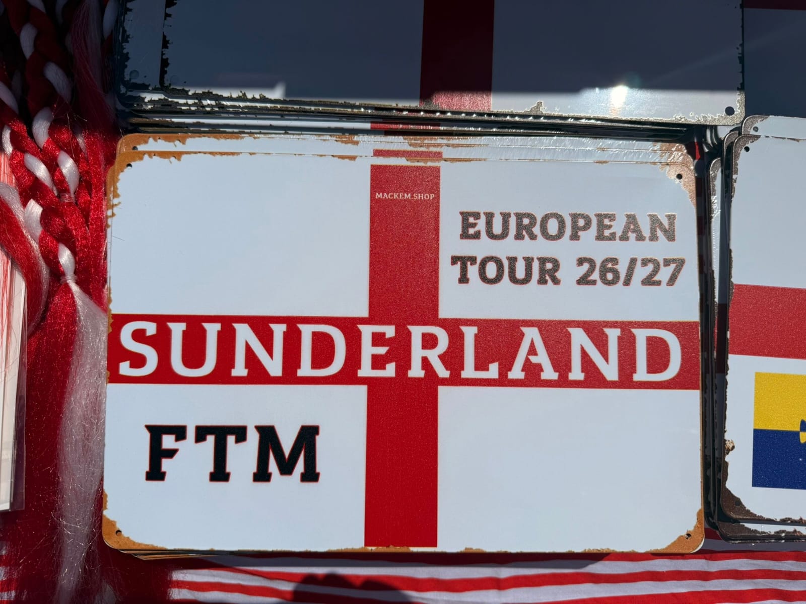 Vintage-style sign with 'Sunderland' and 'European Tour 26/27' text on a red and white background.