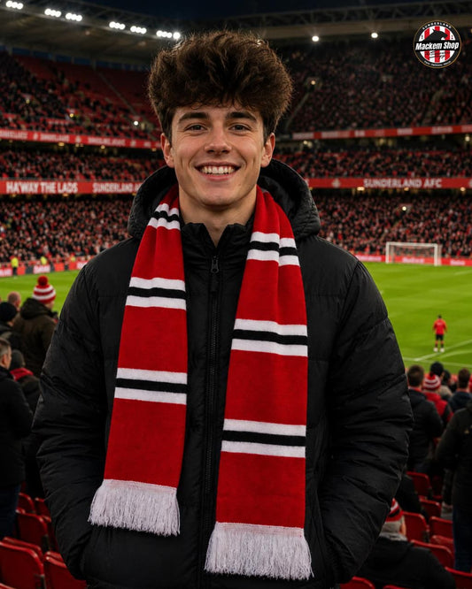 Person wearing a red scarf with black and white stripes in a stadium setting