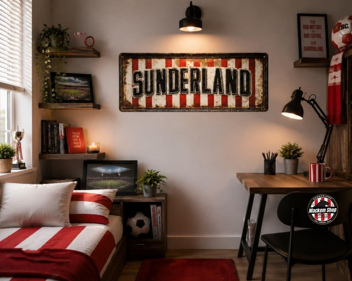 A rustic metal sign reading 'SUNDERLAND' with red and white vertical stripes hangs on a wall in a styled bedroom. The room includes a bed with red-and-white bedding, a desk with a black chair, shelves with books and plants, and warm overhead lighting.