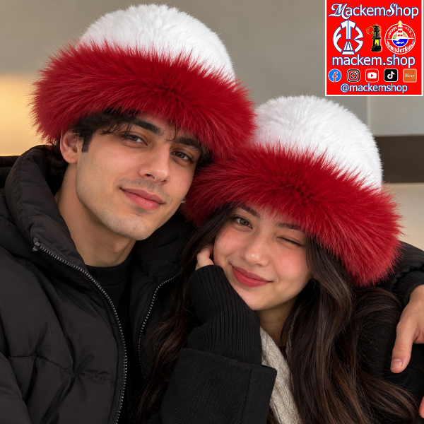 Two people wearing matching red and white faux fur hats, posing closely together. The man wears a black puffer jacket, and the woman wears a black knit top, and a MackemShop logo is on the top right corner.
