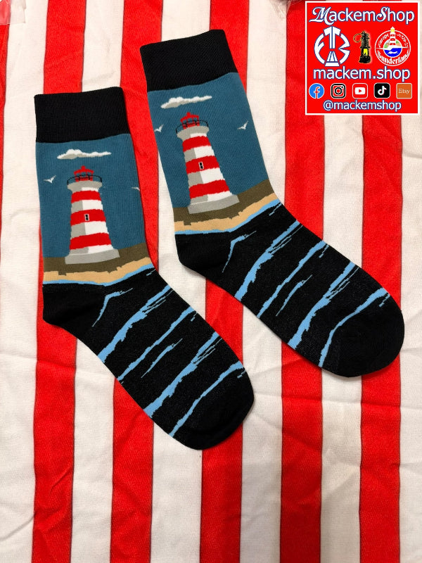 A pair of crew socks laid flat on a red and white striped fabric background. The socks have black cuffs and toes, light blue and black striped lower sections, and a printed lighthouse design on the upper portion, and a MackemShop logo on top right corner.