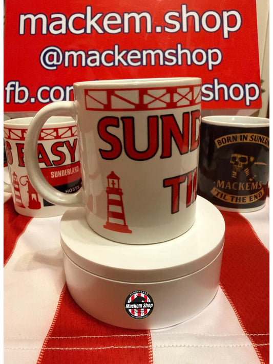 White mug with Sunderland Till I die Text and lighthouse design on a red and white checkered tablecloth, with 'mackem.shop' branding in the background.