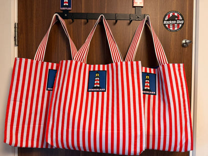 Multiple Sunderland tote bags hanging side by side showing front design and stripes