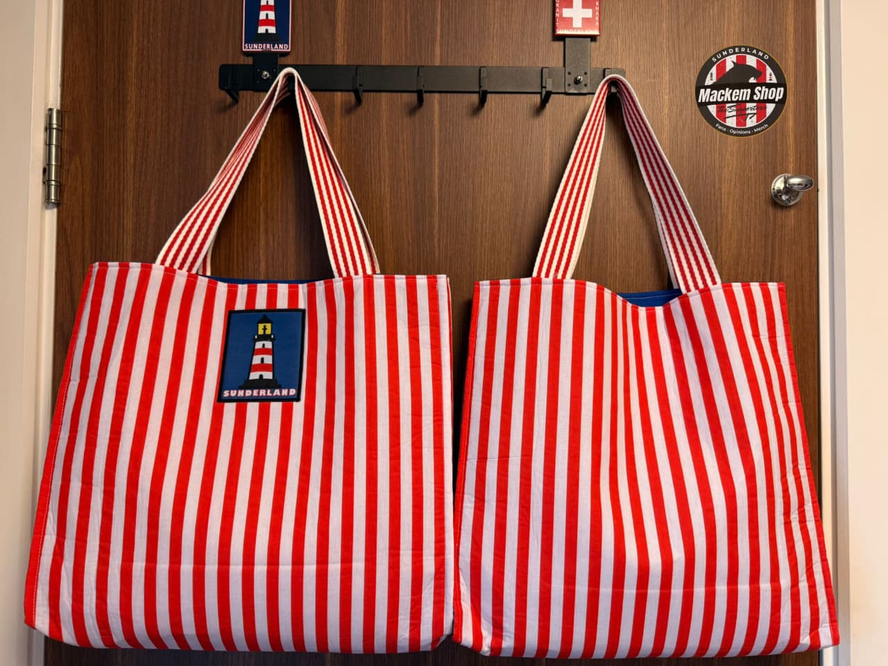 Sunderland tote bag front view with lighthouse patch and red and white stripes hanging on door