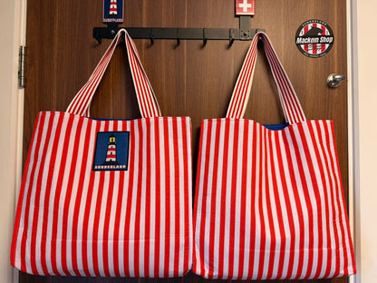 Sunderland tote bag front view with lighthouse patch and red and white stripes hanging on door