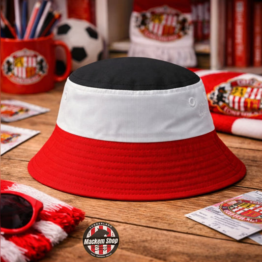 Red and white bucket hat on a wooden surface with sports-themed items in the background.