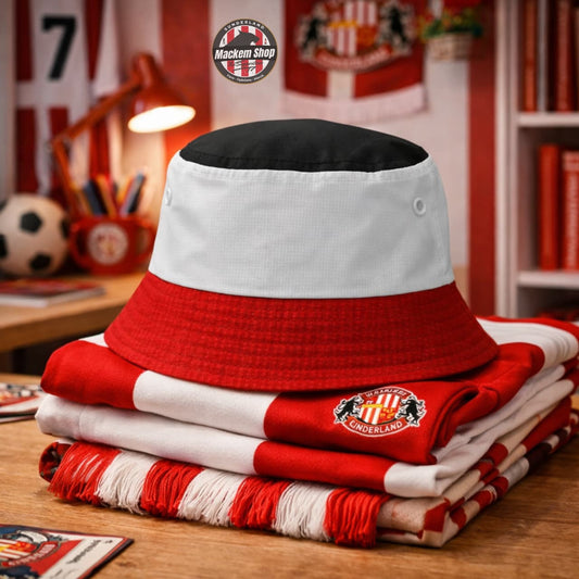 Sunderland Tricolor Bucket hat by Mackem shop placed on a Stack of red and white clothing with a logo on a desk in a room with sports-themed decor.