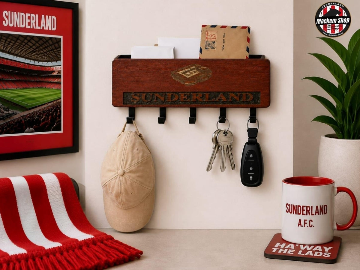 A wooden wall-mounted letter board and key holder with black hooks, shown in a styled home setting. The board is engraved with 'SUNDERLAND'.