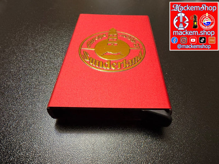 A red RFID Card Wallet with a gold 'Sunderland' seal on the cover, resting on a dark textured surface. A 'mackemshop' Logo is visible in the top right corner.