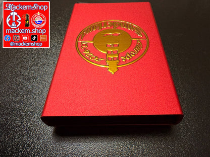A red RFID Card Wallet with a metallic gold foil emblem on the front, photographed on a dark textured surface. A 'Mackemshop' logo overlay is visible in the top-left corner.