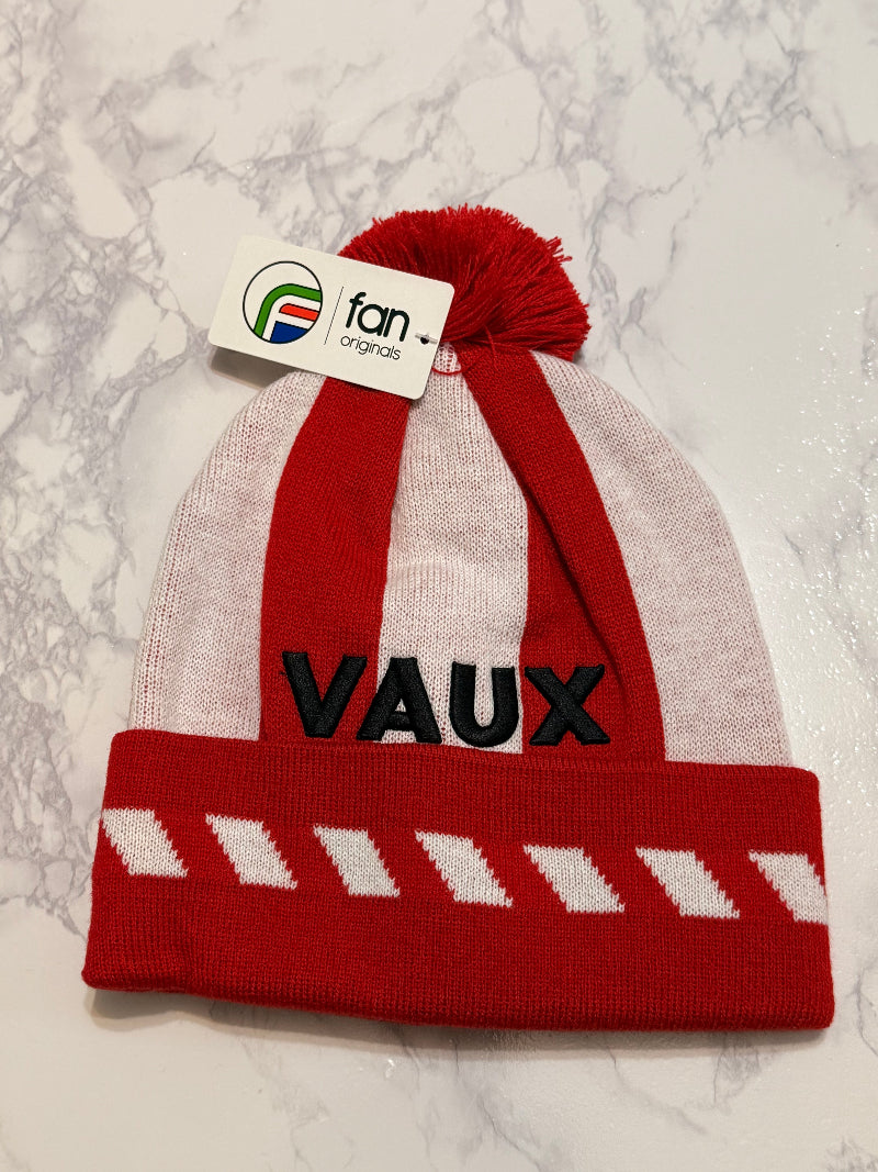 Red and white knit beanie with 'VAUX' branding on a marble surface