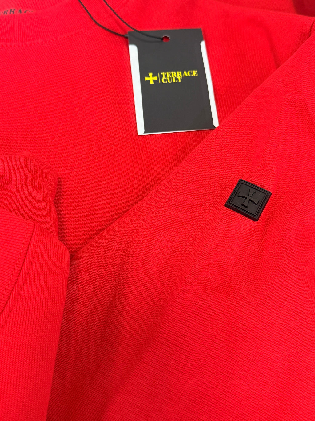 Red fabric with a black tag featuring a logo and text.