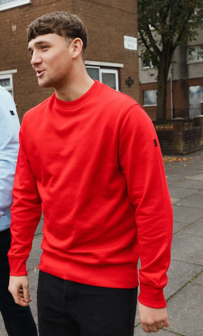 Person wearing a Terrace Cult red sweatshirt by Mackem Shop walking on a street.