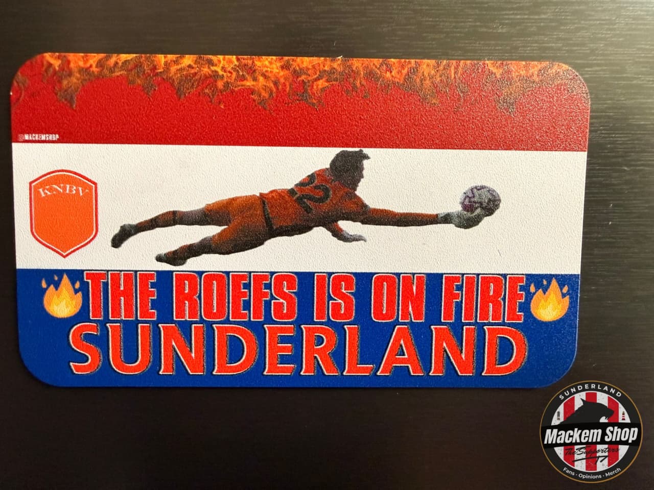 Soccer-themed product with a player diving for the ball, text 'The Roefs is on Fire Sunderland', and branding elements.