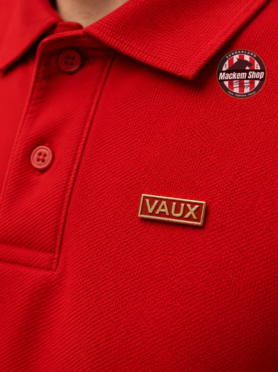 Close-up of a red polo shirt with 'Vaux' badge and 'Mackem Shop' logo.