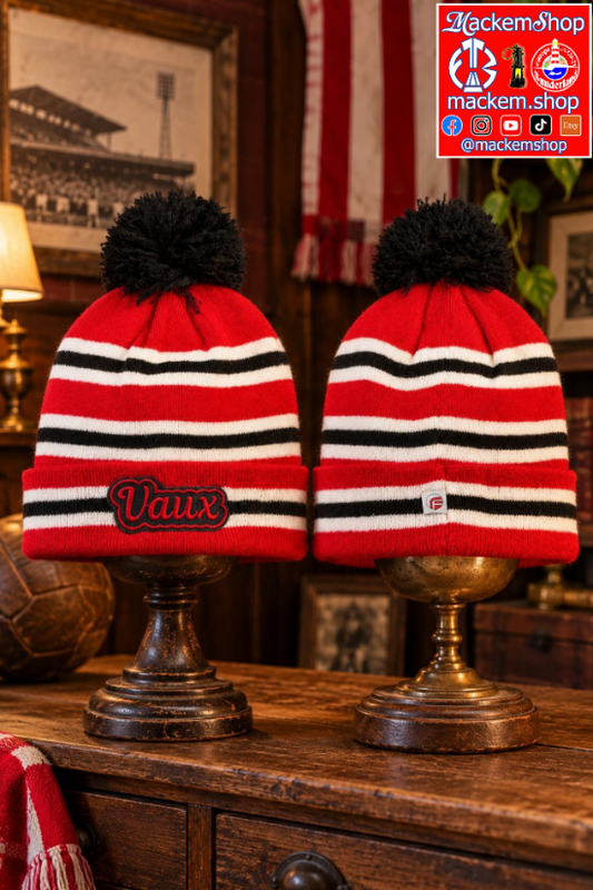 Two red, black, and white striped knit beanie hats with black pom-poms are displayed on dark wooden stands in a rustic indoor setting. The left beanie has 'Vaux' embroidered on the front, and a 'MackemShop' logo overlay is visible in the top right corner.