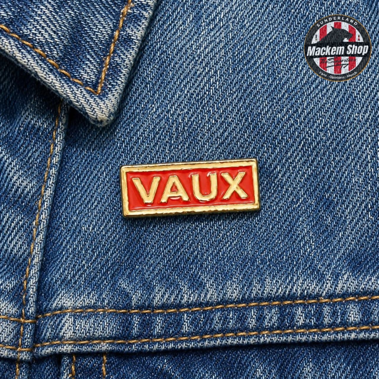 Red 'VAUX' pin on a blue denim jacket with a Mackem Shop logo in the corner.