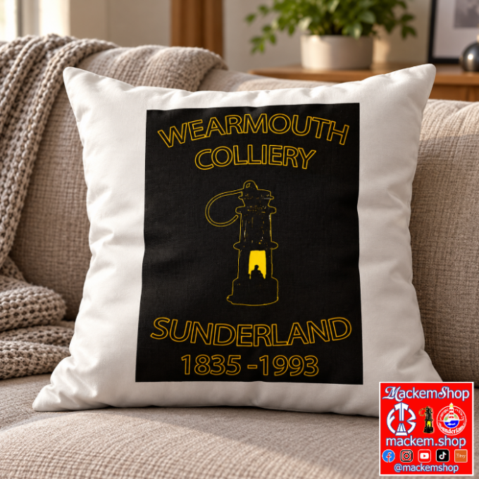 A square white throw pillow with a black graphic print featuring the text 'WEARMOUTH COLLIERY' and 'SUNDERLAND 1835-1993' in yellow, styled on a beige sofa in a living room setting, with MackemShop logo overlay in right bottom corner.
