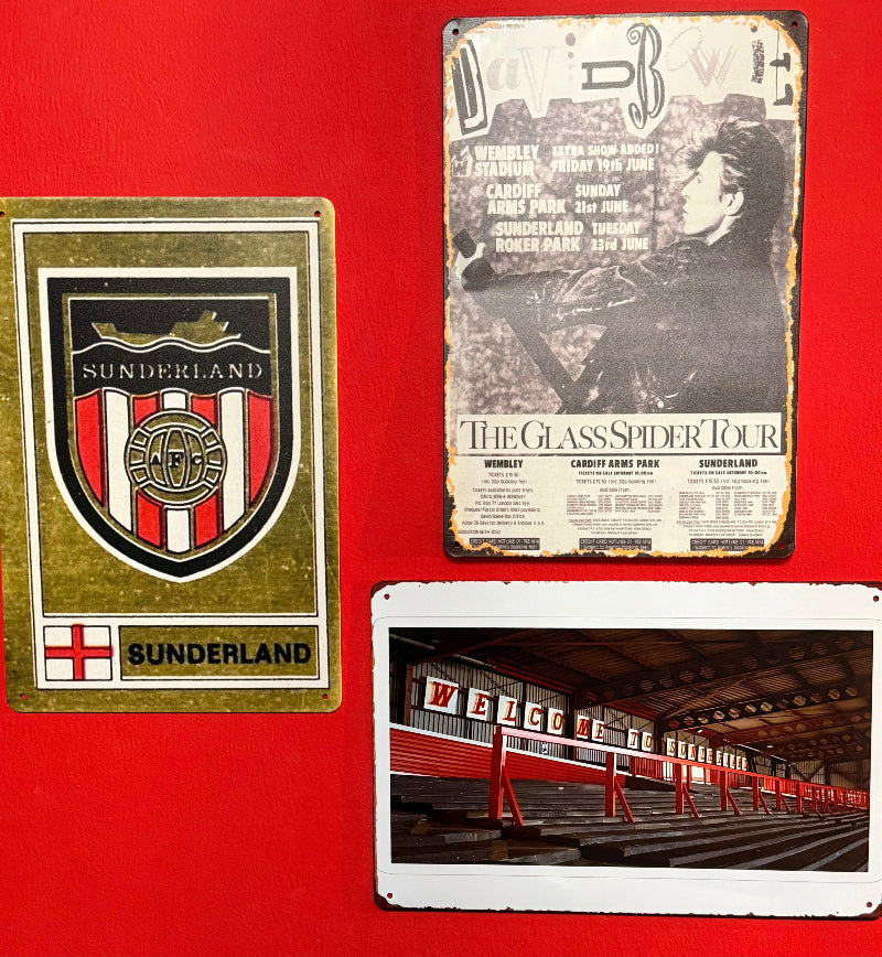 Three metal signs featuring a Sunderland logo, a concert poster, and a stadium image on a red background.