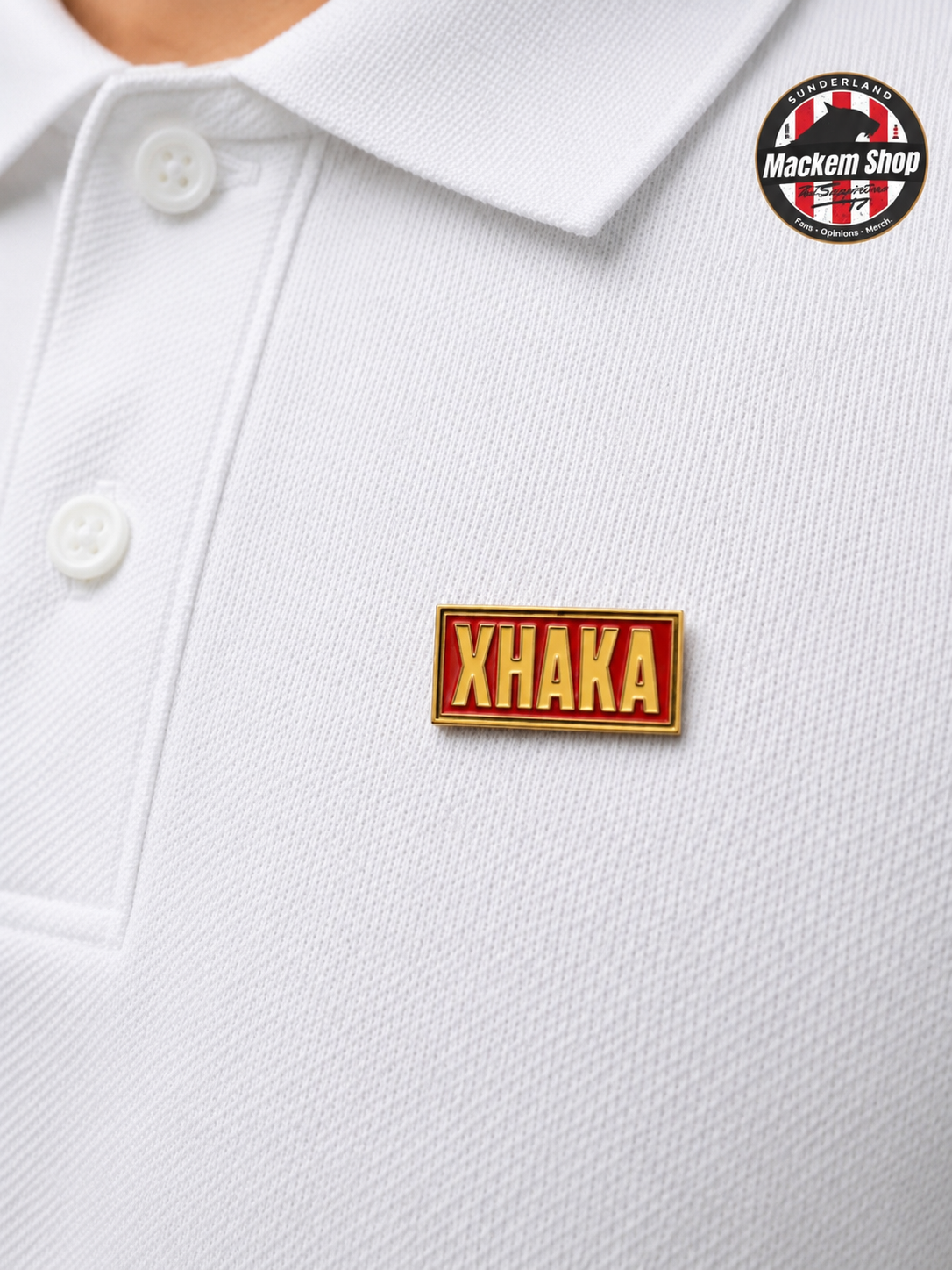 White polo shirt with a red and yellow 'Xhaka' badge on the chest.